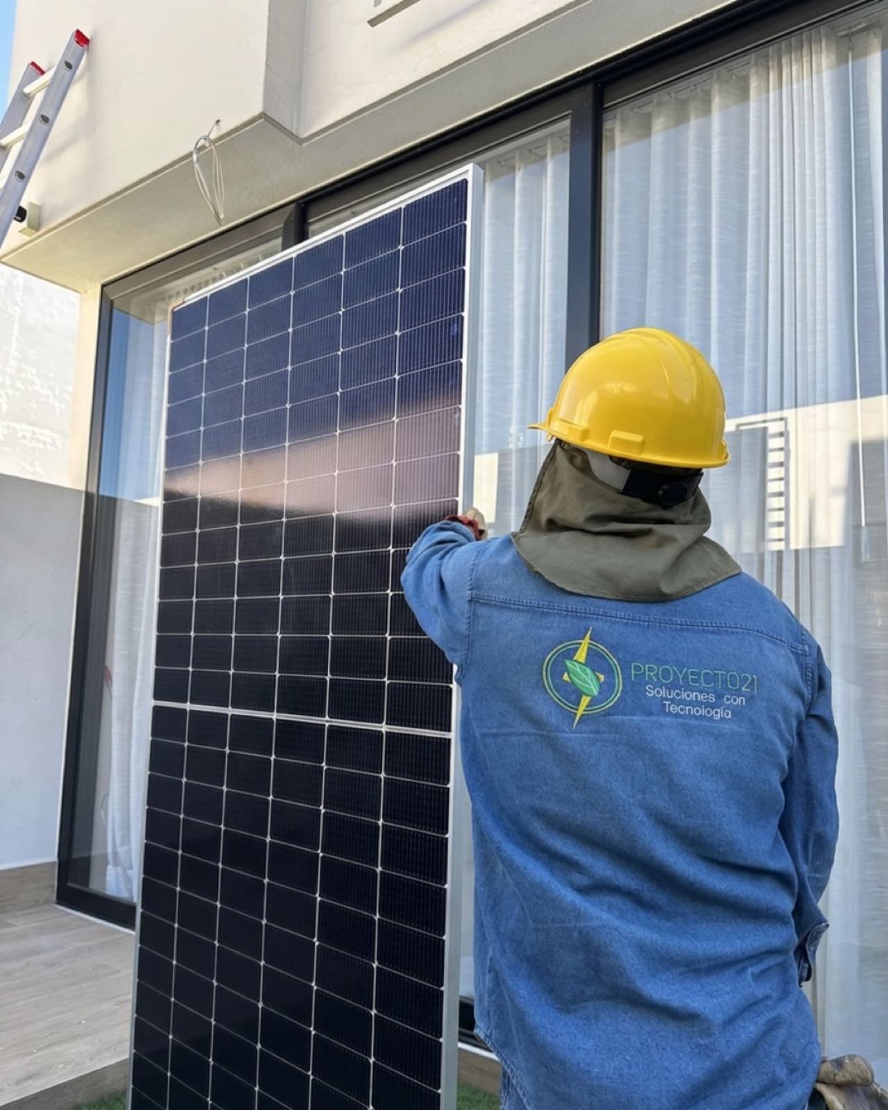 Técnico de Proyecto 21 colocando un panel solar en la fachada de una casa